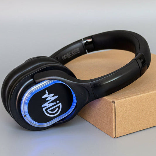 Black headphones with blue accents on a cardboard box against a gray background