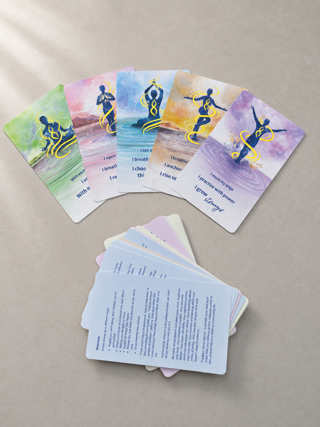 Set of cards with watercolor designs and text on a beige surface