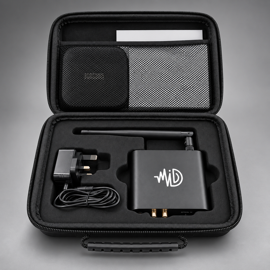 An open black zippered carrying case displaying a black electronic device with a white logo, a power adapter, a coiled cable, a mesh pocket, and a small round accessory on a gray gradient background.