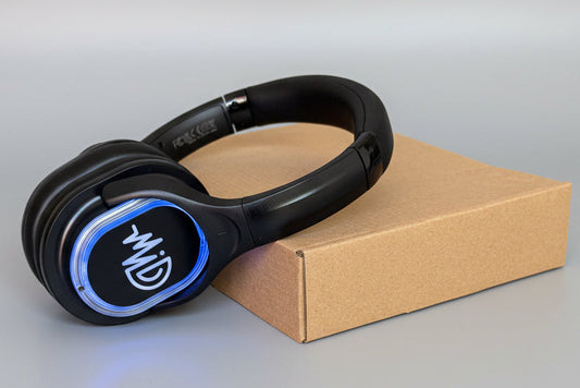 Black headphones with blue accents on a cardboard box against a gray background