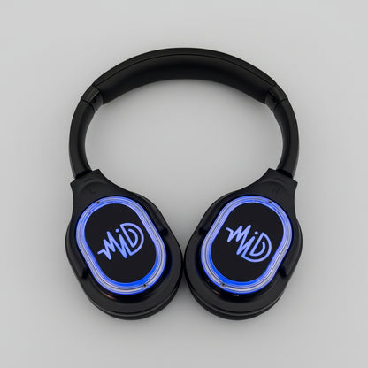 Black headphones with blue LED display on a cardboard box against a concrete floor background